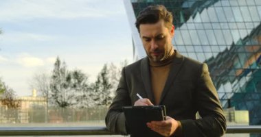 Dijital tablet kullanan neşeli genç iş adamı. İşten önce sabah rutini