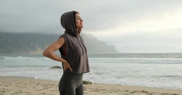 Fille de sport en vêtements de sport avec les yeux fermés profitant du son des vagues de l'océan — Video