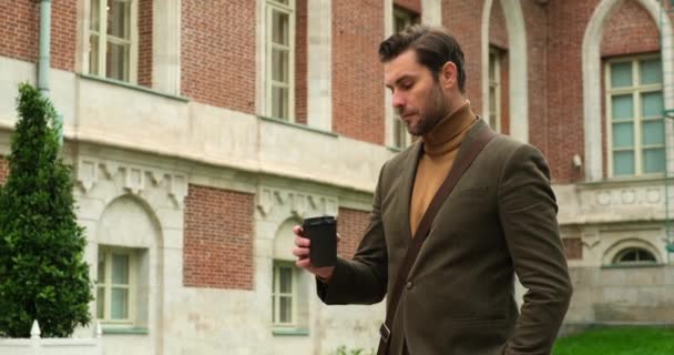 Pensativo hombre de negocios guapo en elegante cos beber café y mirar hacia otro lado — Vídeos de Stock