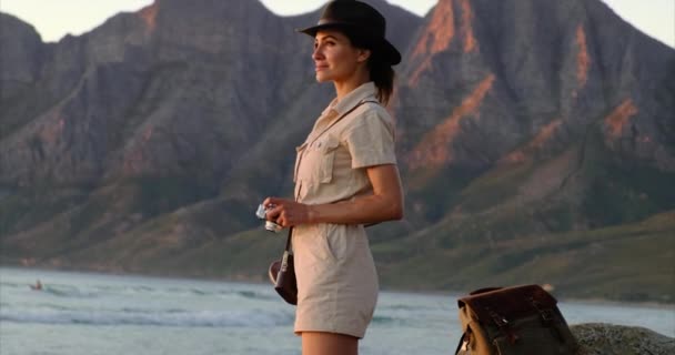 Une fille dans un chapeau de safari fait une photo au coucher du soleil océan Cape Town — Video