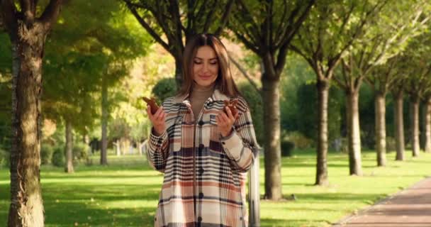 Girl in the park holds two Easter bunnies made of glaze in her hands and smiles — Vídeo de Stock