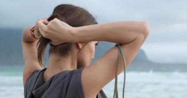 Üstteki sporcu kız antrenmandan önce saçı kuyruğa bağlamış. atlama ipi