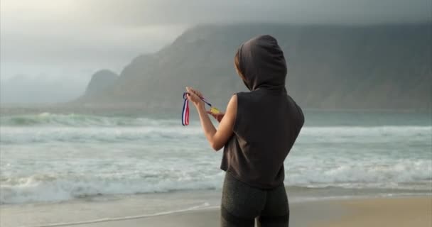 Концепция награждения и победы. спортсменка с золотой медалью на руках — стоковое видео