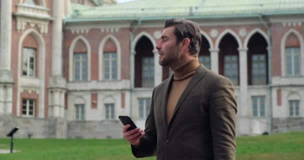 Hombre millennial profesional celebración moderna smartphone mensaje de texto — Vídeo de stock