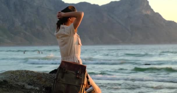 砂のビーチとバックパックを保持している女性旅行者スタンド。旅行のコンセプト. — ストック動画