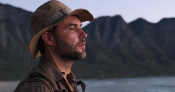 Porträt eines männlichen Reisenden mit Safari-Hut am Strand des Ozeans — Stockvideo