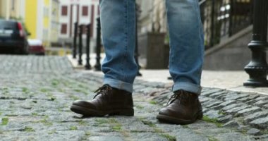 Şehirde kareli retro pantolonlu bir adam var. Yaz modası, şık erkek ayakkabıları.