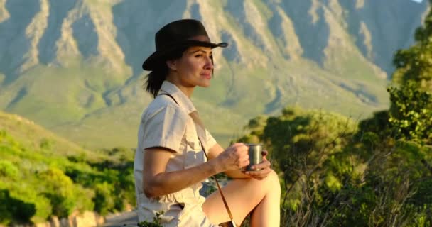 Turist kvinna dricker en drink från en kopp och njuter av landskapet i bergen — Stockvideo