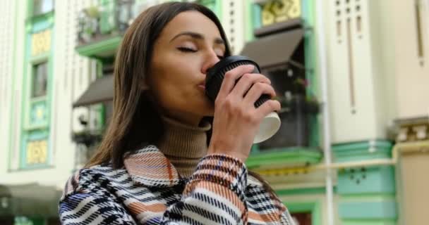 Vrolijke vrouw in de straat drinken's ochtends koffie in de zon. — Stockvideo