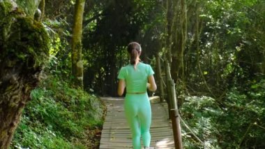 beautiful athletic woman with a thin body runs along the path in the park