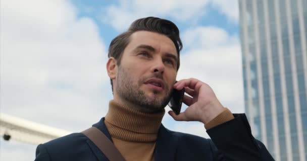 Uomo d'affari maturo di successo che parla sul telefono cellulare al di fuori del business center. — Video Stock