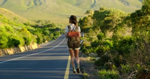 Girl traveler with a backpack hitchhiking in America among the desert — Stock Video