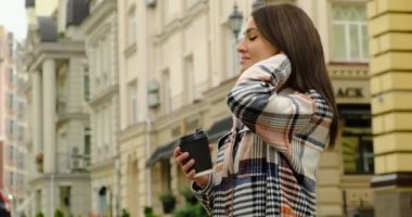 Sabahları elinde çay tutan gülümseyen bir kadın.