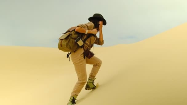 年轻美丽的女人在沙漠中旅行 年轻的男人独自背着沙漠背景的旅行背包 夏日的晴天 桑迪的沙丘和蓝天 自由概念 — 图库视频影像