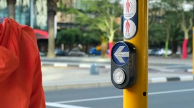 Yakın plan kadın eli trafik lambasındaki bir düğmeye basıyor. Kasabanın en güzel sonbahar manzaraları. Yaya geçidindeki kız. Otoyol, yaya geçidi ve yol tabelası. Güvenlik için caddede yaya geçidi.
