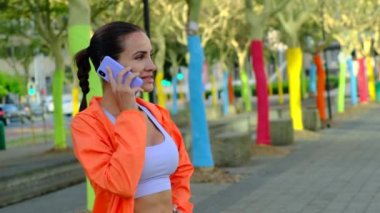 Cep telefonu kullanan mutlu üniversite öğrencisi kız. İş kadını kahve içiyor ve gülümsüyor. Elinde akıllı telefon tutan sıradan bir kadının portresi. Renkli ağaçların yanında konuşan şık bir kız.