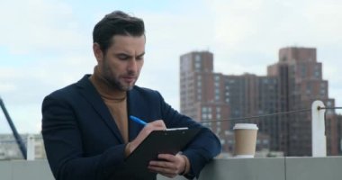 Güneş gözlüklü bir adam tabletle kontrat imzalıyor. İş ve teknoloji kavramı. Düşünceli bir adam elinde kalemle başka yere bakıyor. Sokaklarda çalışan bir web tasarımcısı. Genç mimar inşaat kontrolü yapıyor.