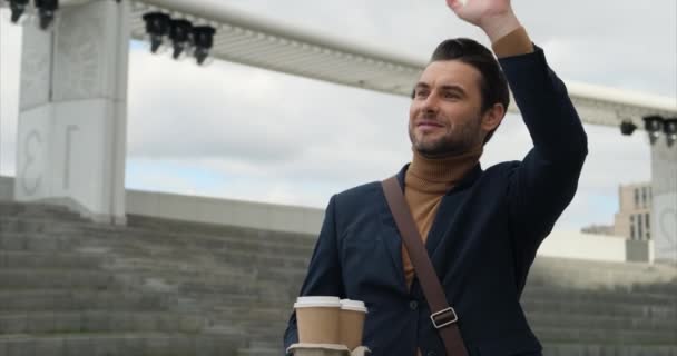 Adamı Takım Elbiseli Elinde Kahve Arkadaşlarına Sallayan Arka Planda Şehir — Stok video