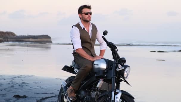 Motocyklista Kurtce Okularach Przeciwsłonecznych Siedzący Motocyklu Patrzący Zachód Słońca Mężczyzna — Wideo stockowe