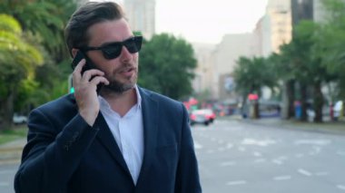 İş adamı tablet kullanır ve telefonla konuşur. Öğrenci tablet kullanıyor ve dışarıda telefonla konuşuyor. Erkek, çantalı bir telefon tutuyor. New York 'ta, Wall Street' te takım elbiseli bir adam telefonda konuşuyor.