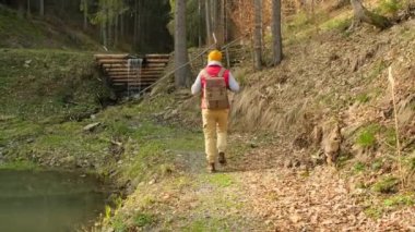 Young man traveler looking landscape at sunset and camping on mountain, Adventure travel lifestyle concept. Man hiking in mountains traveling solo with backpack outdoor active vacations in Norway