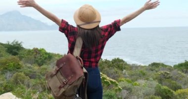 Young beautiful woman with backpack solo travel on tropical island mountain peak in summer sunny day. Cheerful female relax and enjoy outdoor lifestyle in summer beach holiday vacation trip