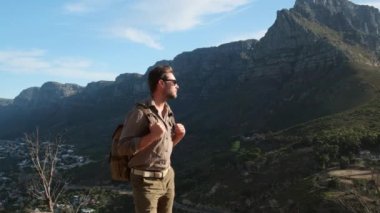 Gün doğumunda Masa Dağı 'yla manzara. Cape Town Güney Afrika, Masa Dağı ve Lions Head 'e bakan. Bir erkek gezgin, Güney Afrika 'daki Cape Town' daki bir aslanın tepesinde duruyor.