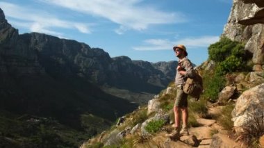 Gün doğumunda Masa Dağı 'yla manzara. Cape Town Güney Afrika, Masa Dağı ve Lions Head 'e bakan. Bir erkek gezgin, Güney Afrika 'daki Cape Town' daki bir aslanın tepesinde duruyor.