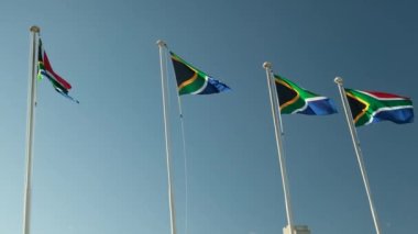 Güney Afrika bayrağı gün batımında gökyüzü arka planında dalgalanıyor. Rüzgarda dalgalanan büyük Güney Afrika bayrağı. Güney Afrika ırk ayrımcılığından bağımsızdır..