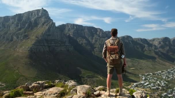 一位身穿狩猎服的男性旅行者穿着运动鞋爬上山顶 带着背包在日落山中远足的人旅行生活方式游手好闲 — 图库视频影像