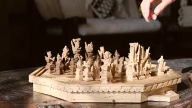 Fikirler, rekabet ve strateji için satranç masası oyunu, iş başarısı konsepti. Takım elbiseli kadın satranç oynuyor. Piyondaki kadın elinin yakın çekimi. Kadın eli el yapımı bir satranç taşı tutuyor.