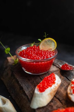 Koyu arkaplanda kırmızı havyar. Havyarlı sandviç.