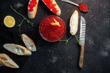 Koyu arkaplanda kırmızı havyar. Havyarlı sandviç.