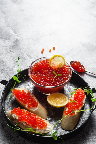 Koyu arkaplanda kırmızı havyar. Havyarlı sandviç.