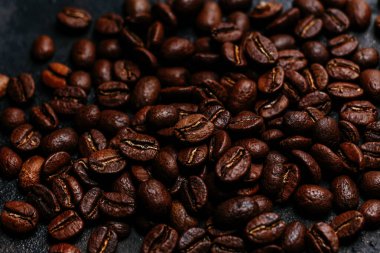 Koyu bir arka planda kavrulmuş kahve çekirdekleri. Kolombiya kahvesi