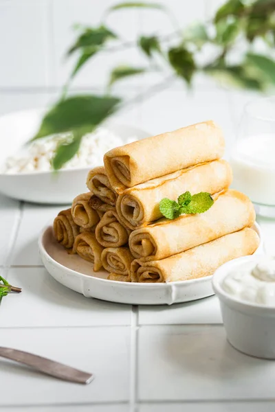 Beyaz arka planda süzme peynirli krepler..