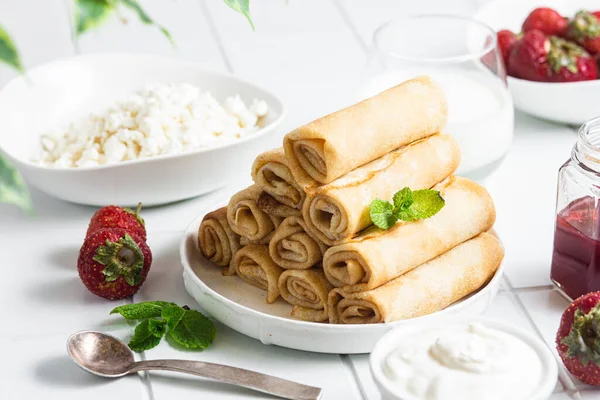 Beyaz arka planda süzme peynirli krepler..