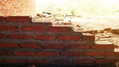 Geleneksel olmayan inşaat alanı. Duvarcılık ihmal edilmiş, sorumsuz, ilerlemeyen, sadece yarısı bitmiş. Bazı kısımlarında duvarların pürüzlü yüzeyleri vardı..