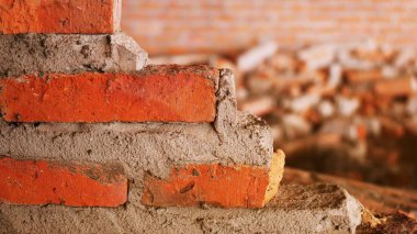 Geleneksel olmayan inşaat alanı. Duvarcılık ihmal edilmiş, sorumsuz, ilerlemeyen, sadece yarısı bitmiş. Bazı kısımlarında duvarların pürüzlü yüzeyleri vardı..