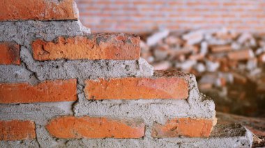 Geleneksel olmayan inşaat alanı. Duvarcılık ihmal edilmiş, sorumsuz, ilerlemeyen, sadece yarısı bitmiş. Bazı kısımlarında duvarların pürüzlü yüzeyleri vardı..