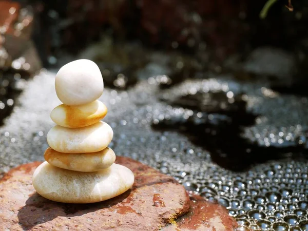 The Balance Stones are stacked as pyramids in a soft natural bokeh background, representing the calm philosophical concept of Jainism\'s wellness.