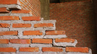 Geleneksel olmayan inşaat alanı. Duvarcılık ihmal edilmiş, sorumsuz, ilerlemeyen, sadece yarısı bitmiş. Bazı kısımlarında duvarların pürüzlü yüzeyleri vardı..