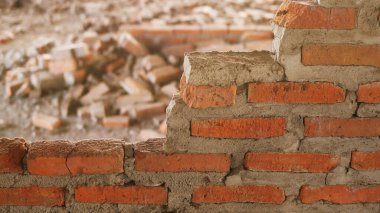 Endüstriyel bir binanın yıkıntıları beton ve tuğla yığınına dönüşüyor. Mühendislerin terk edilmiş inşaattaki başarısızlıklarının yol açtığı pürüzlü enkaz..