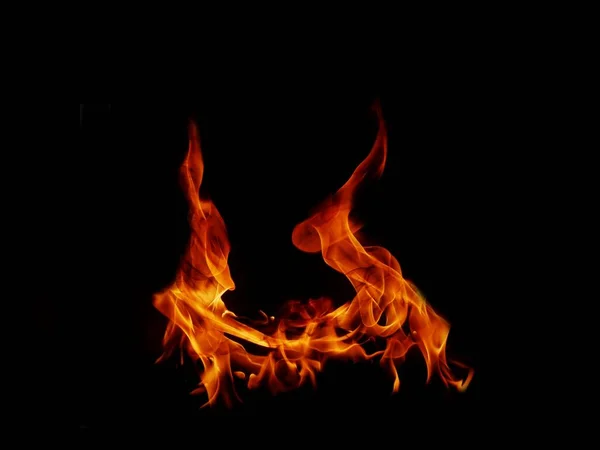 一个美丽的火焰形状和想象的一样 就像来自地狱 有着危险而炽热的黑色背景 — 图库照片