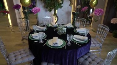 Restoranda parti için dekore edilmiş bir masa. Servis tabağı, peçete, çatal bıçak takımı, bardak.