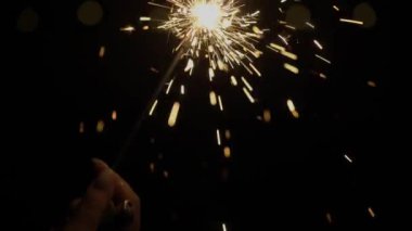 Kişi elinde maytap tutuyor. Tatil için havai fişekler, yeni yıl, Noel.