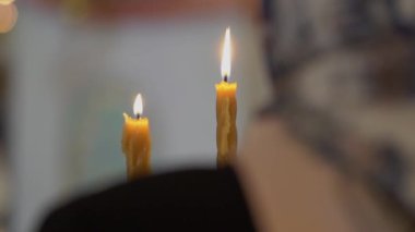 Kadın kilisede ayin için mum tutuyor. Din, dualar.