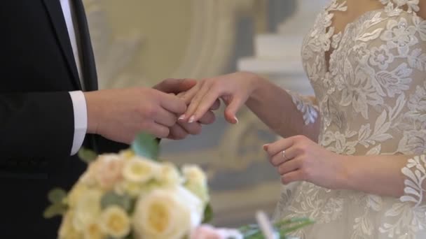 Bruid en bruidegom wisselen trouwringen uit bij de ceremonie. Doe de ring om.. — Stockvideo