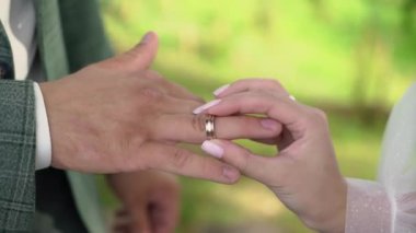 Gelin ve damat törende alyanslarını değiş tokuş ederler. Parmak mücevher yüzüğünü tak..