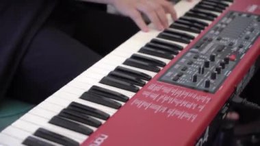 PSKOV, RUSSIA - AUGust, 8, 2021: Piyanist piyano sentezleyicisinde müzik çalıyor.